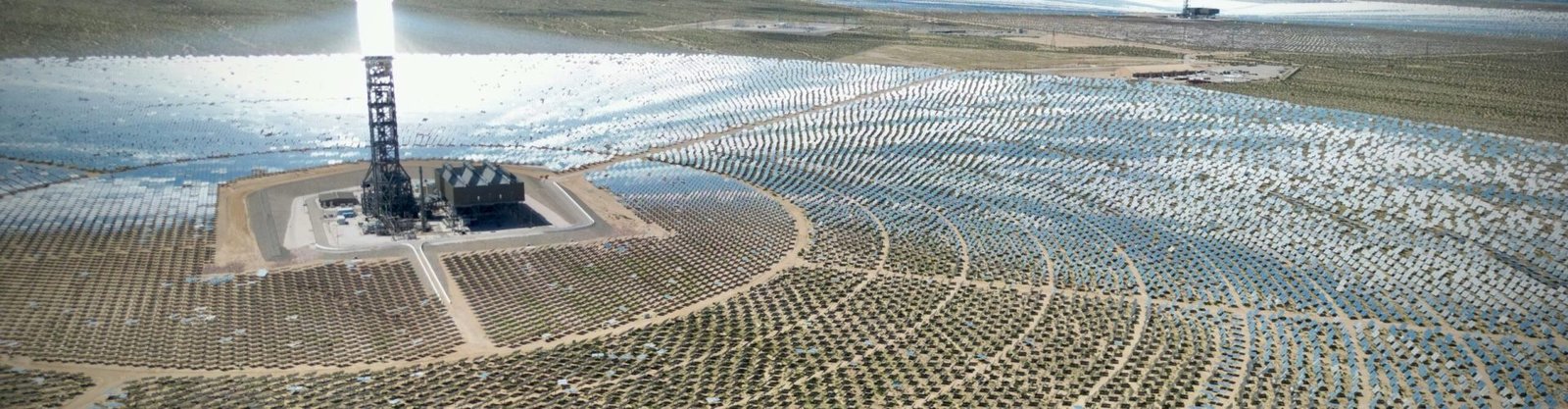 Stunning aerial view of the Ivanpah Solar Electric Generating System with mountainous backdrop.